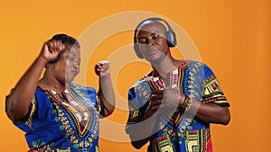 Happy ethnic couple listening to favorite song on headset