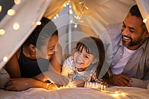 Happy ethnic family playing together in cozy hut with daughter