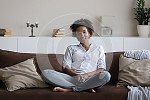 Happy ethnic female renter relax watching TV