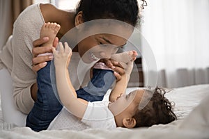 Happy ethnic mother play relax with cute little baby girl