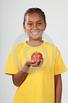 Happy ethnic school girl 10 holding red apple