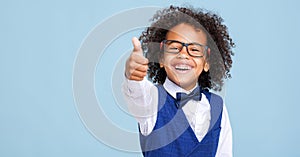 Happy ethnic schoolboy in formal suit and glasses approving school education