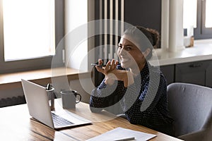 Happy ethnic woman talk on smartphone on loudspeaker