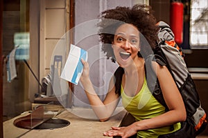 Happy and euphoric backpacker female tourist shows ticket for he