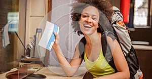 Happy and euphoric backpacker female tourist shows ticket for he