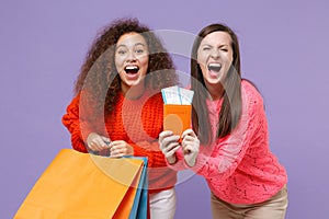 Happy european african american women friends in sweaters isolated on violet purple background. People lifestyle concept