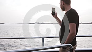 Happy European male traveler making a video using smartphone