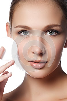 Happy european woman with cotton pad, isolated on white background. Beauty fresh girl cleaning face with cotton swab. Beautiful y