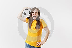 Happy European young woman, football fan or player in yellow uniform holding soccer ball support favorite team isolated