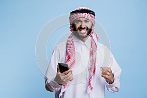 Happy excited arab using mobile phone