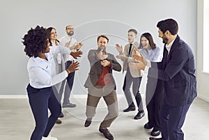 Happy excited business people group men and women having fun in office happy to make a good deal.