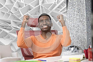 Happy excited businessman celebrate his success. Winner, black man in office reading on laptop, copy space