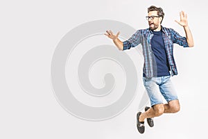 Happy excited cheerful young man jumping and celebrating success isolated on a white background