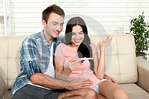 Happy excited couple making positive pregnancy test and celebrating