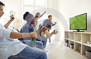 Happy excited diverse friends screaming while watching football match on TV at home