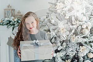 Happy excited girl child holding christmas gift box