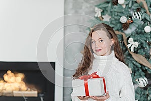 Happy excited girl child holding christmas gift box