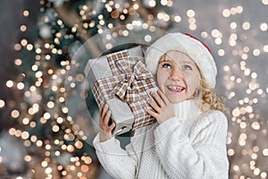 Happy excited girl child holding christmas gift box