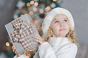 Happy excited girl child holding christmas gift box