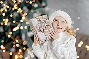 Happy excited girl child holding christmas gift box