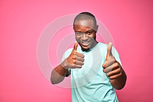 happy and excited handsome young black man giving thumbs up with both hands