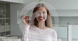 Happy excited homeowner woman showing key from new home