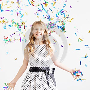 Happy excited laughing kid under sparkling confetti shower