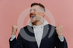 Happy excited man with closed eyes raising clenched fists and celebrating victory