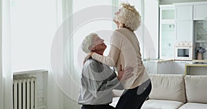 Happy excited mature couple dancing to music together at home