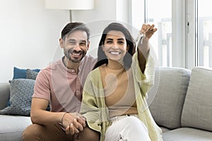 Happy excited middle aged couple showing keys after moving