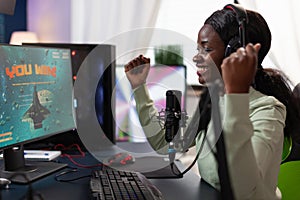 Happy excited pro gamer woman raising hands after winning