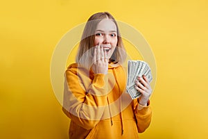 Happy excited rich young woman win money cash. Lady hold Dollar stack surprised rejoices at lottery victory. Teen girl