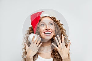 Happy excited surprised young woman in Santa hat smiling. Christmas and New Year party portrait