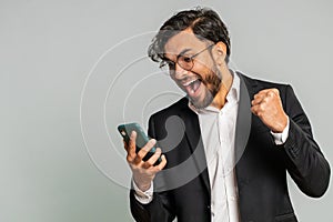 Happy excited winner man use smartphone celebrating success, winning play game, good lottery news