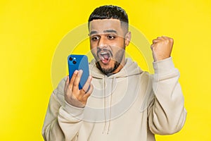 Happy excited winner man use smartphone celebrating success, winning play game, good lottery news