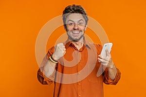 Happy excited winner man use smartphone celebrating success, winning play game, good lottery news