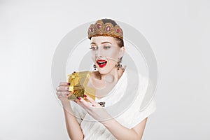 Happy excited woman beauty pageant contestant holding gift / present. Cute surprised mixed Asian Chinese / Caucasian female model