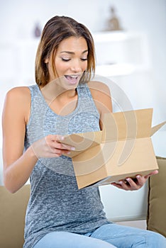 Happy excited woman at home unboxing gift photo