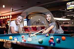 Happy and excited women playing billiard together