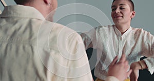 Happy excited young Caucasian student man and woman in business clothes have fun dancing together at office slow motion.