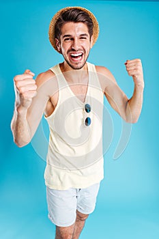 Happy excited young man standing and celebrating success