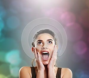 Happy excited young woman celebrating over colorful background