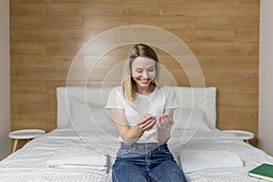 Happy, excited young woman holding a pregnancy test looking at the positive result in joy.