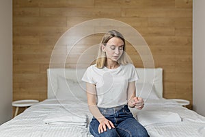 Happy, excited young woman holding a pregnancy test looking at the positive result in joy.