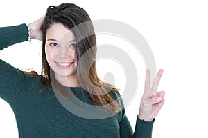 Happy excited young woman showing the sign of victory on white background