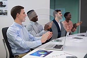 Happy executive applauding during meeting