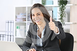 Happy executive gesturing thumbs up at office