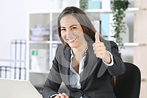 Happy executive gesturing thumbs up at office photo