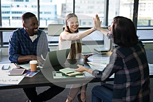 Happy executives giving high five to each other