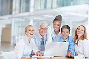 Happy executives using laptop. Portrait of happy business people working together on laptop.